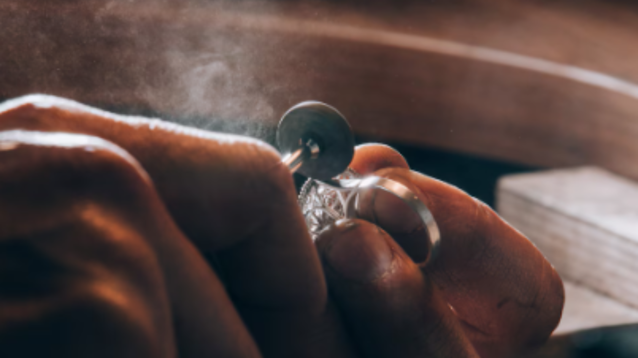 Two hands repairing a piece of diamond jewelry.