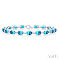 6X4 MM Oval Cut Blue Topaz and 1/6 Ctw Round Cut Diamond Semi-Precious Tennis Bracelet in 10K White Gold