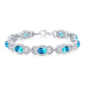 7x5 MM Oval Shape Blue Topaz and 1/10 Ctw Round Cut Diamond Semi-Precious Bracelet in Sterling Silver